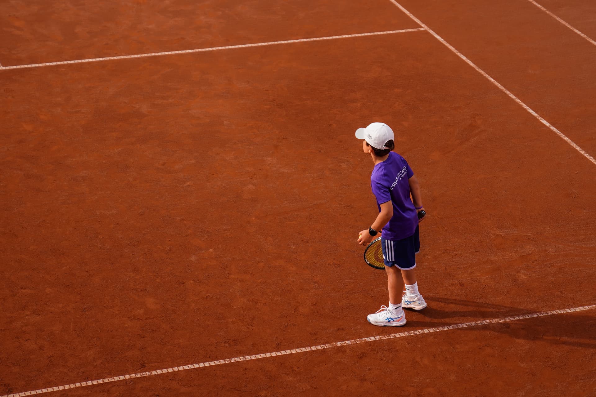 Young tennis player training on a clay court
